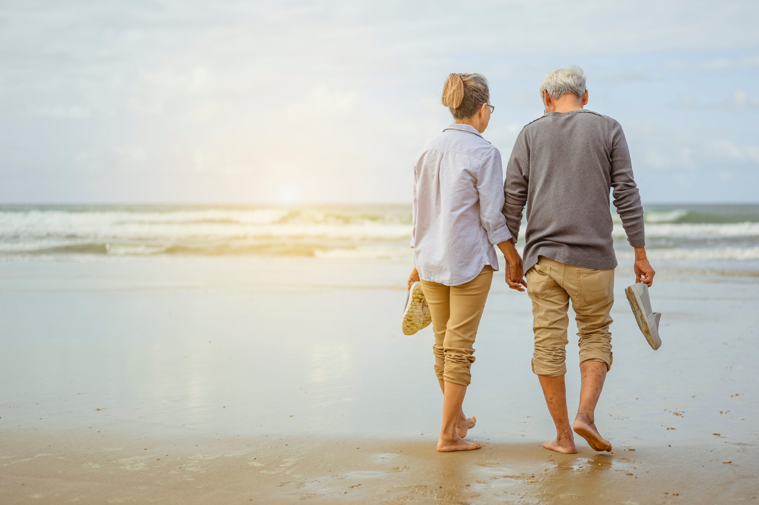 Couple Walking Barefoot on Beach