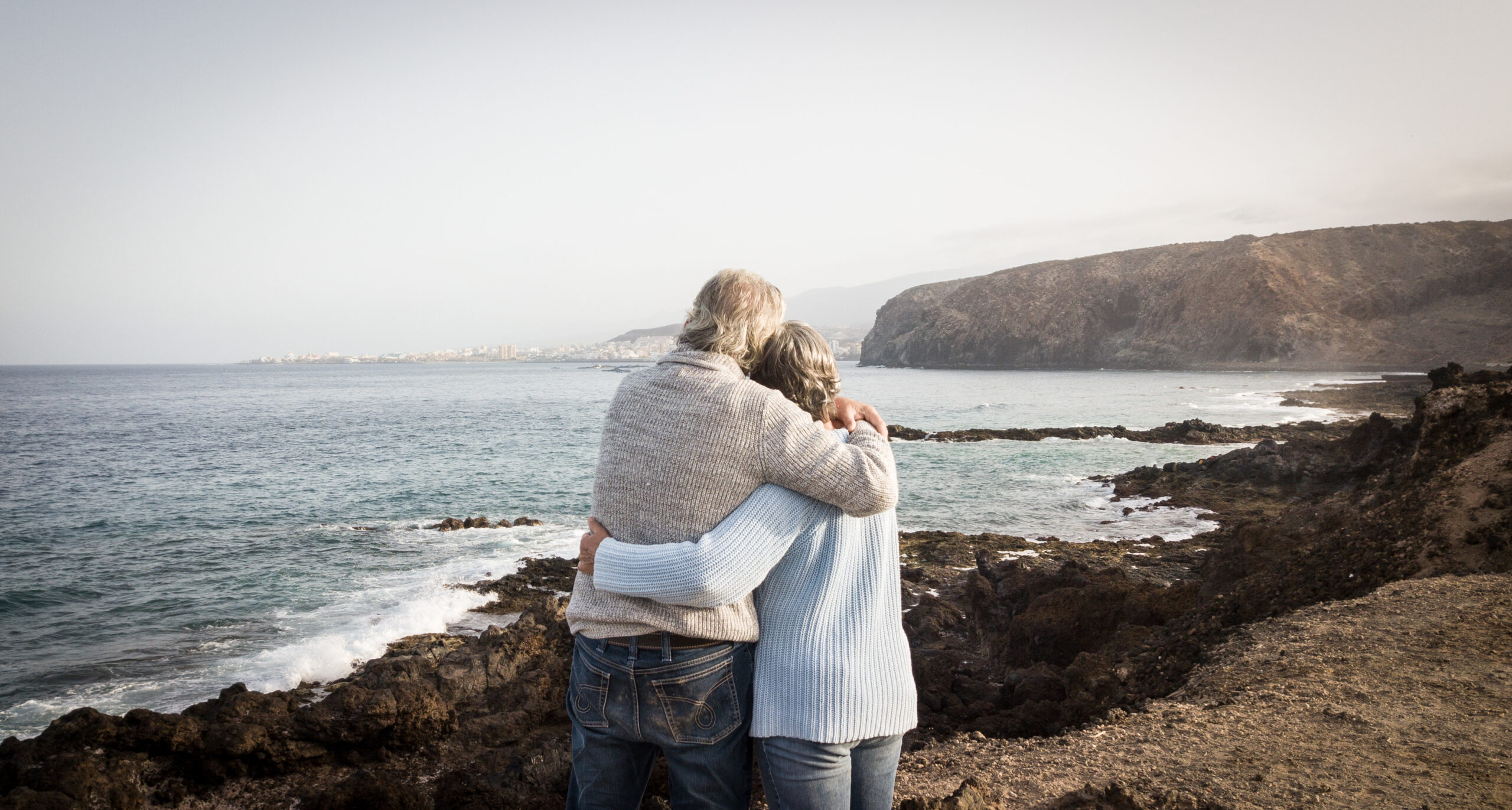 Elderly couple looking out to sea